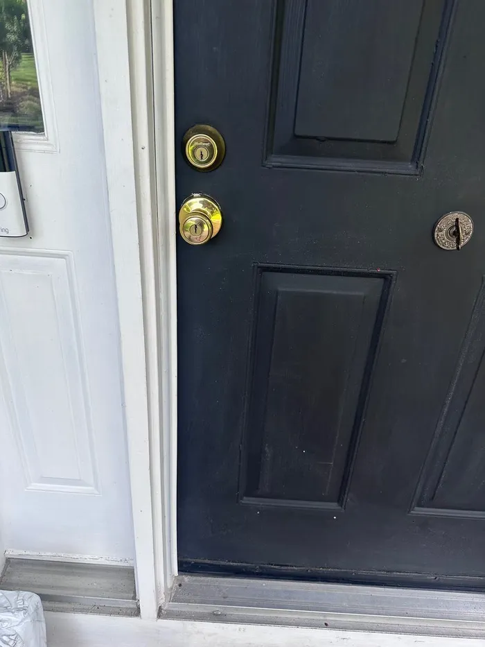 Black front door with a deadbolt and knob