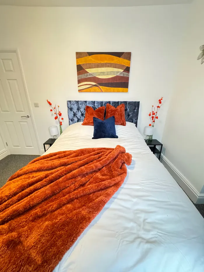 Double bedroom with orange throw at the Barnsley town centre home