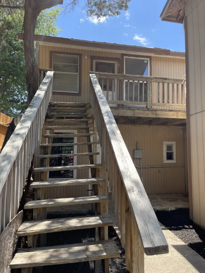 Exterior stairs before: weathered wood stairs up to an old deck