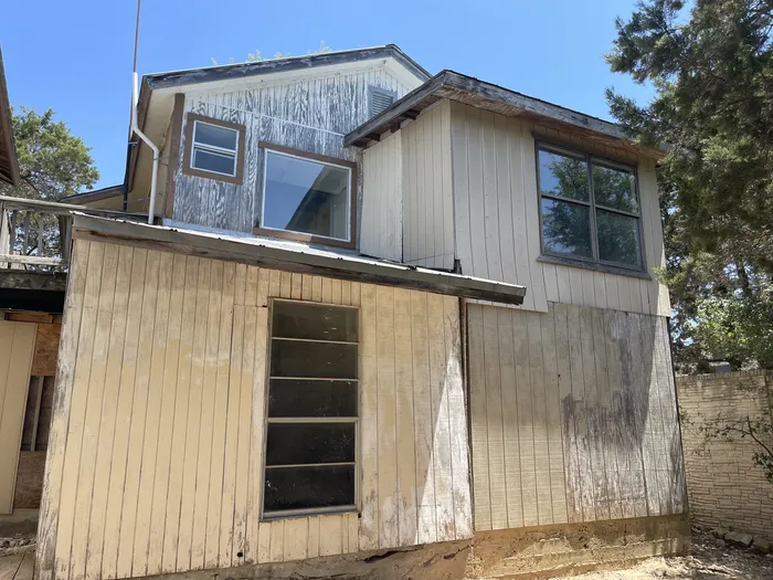 Back of the house before: weathered siding and old windows
