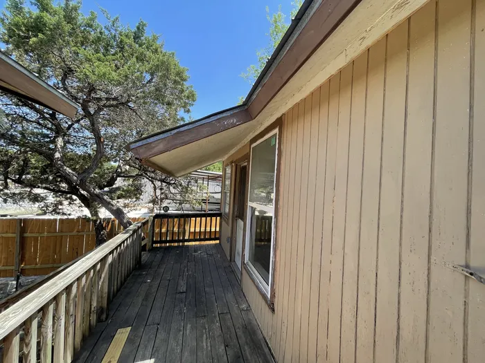 Side deck before: worn boards, painted rails and old siding