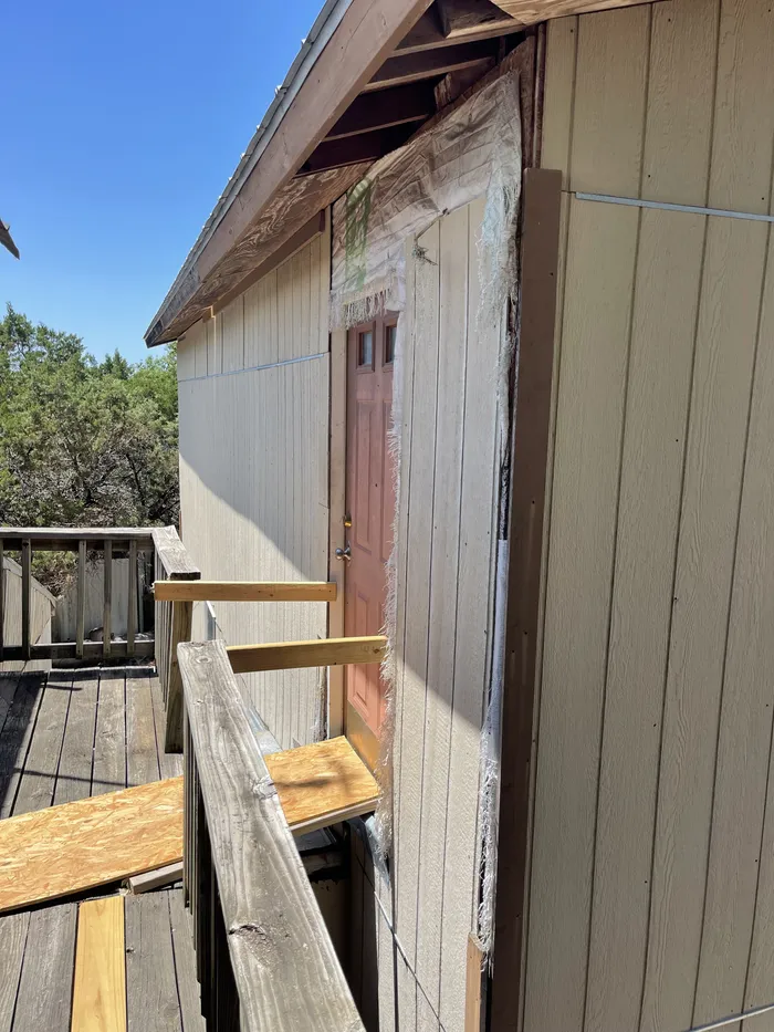 Siding before: weathered panels and an old door off a worn deck