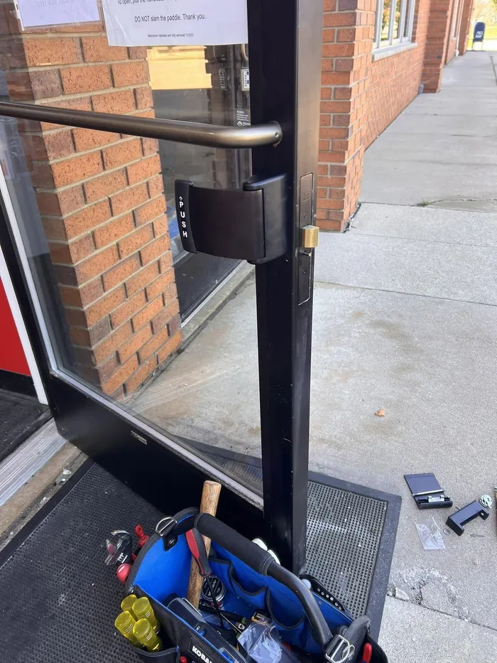 Locksmith tools set up at a storefront door during a service call