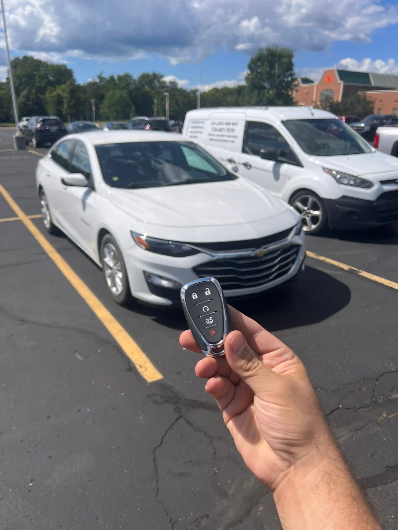 Smart key for a white Chevrolet Malibu in a parking lot