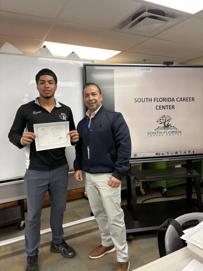A graduate holding his SFCC certificate