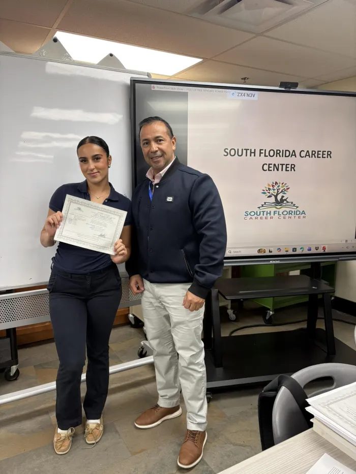 A graduate holding her SFCC certificate