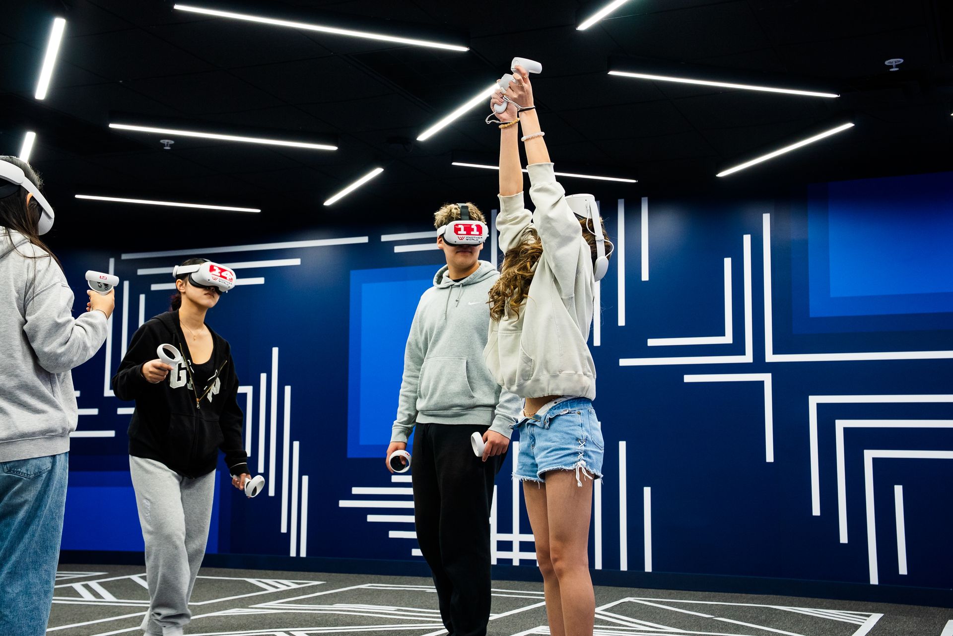 Students reaching up mid-game in the blue arena