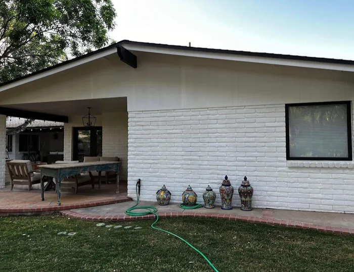 White painted brick home with a covered patio