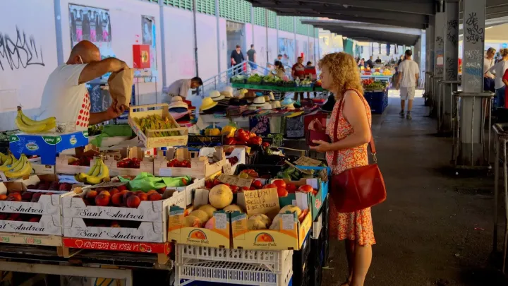 A busy fresh-produce market stall with crates of fruit and vegetables, Mashamba's guide to who buys Ugandan produce in the UK and Europe