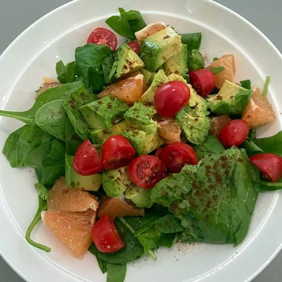 Spinach salad with avocado, grapefruit and tomatoes