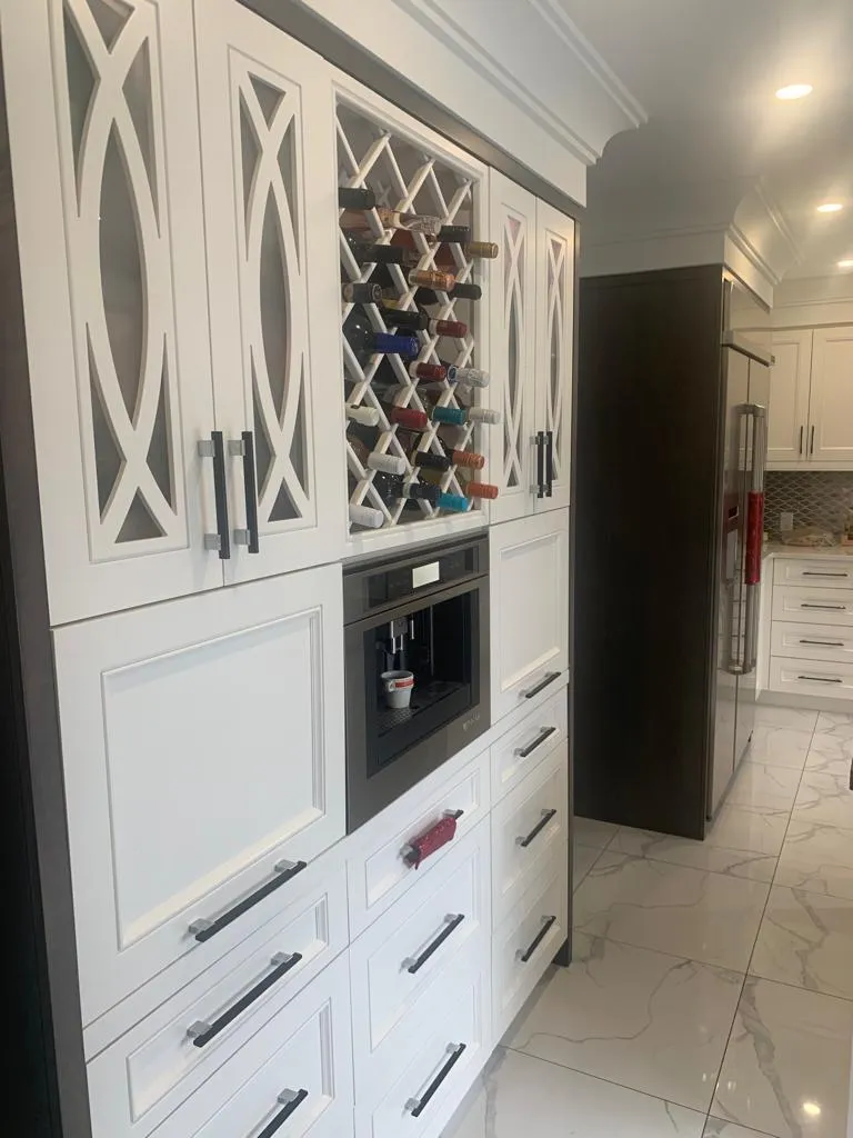 Floor-to-ceiling white cabinetry with glass-front doors and a built-in wine rack