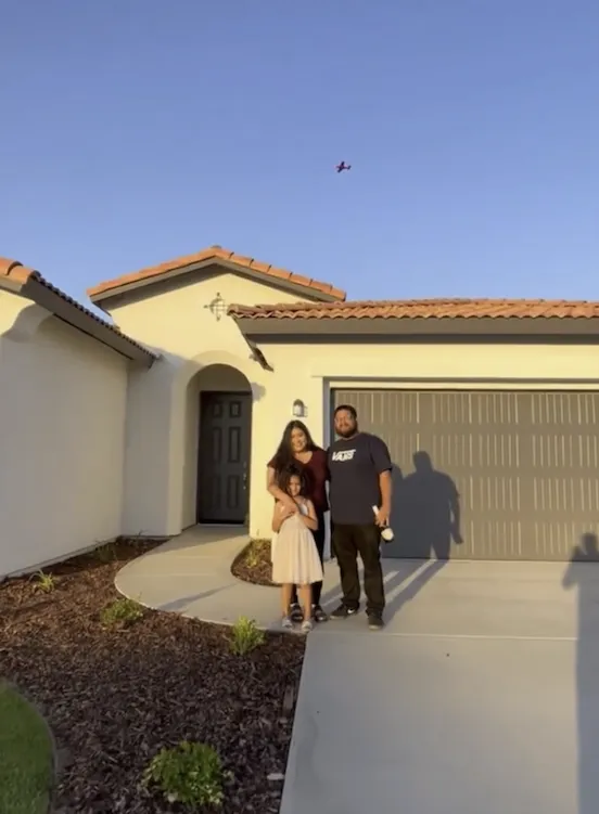Una familia frente a su casa nueva