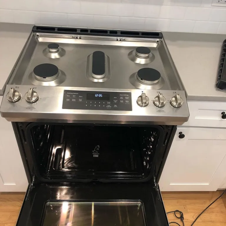 Stainless steel gas range with spotless oven interior after kitchen deep cleaning