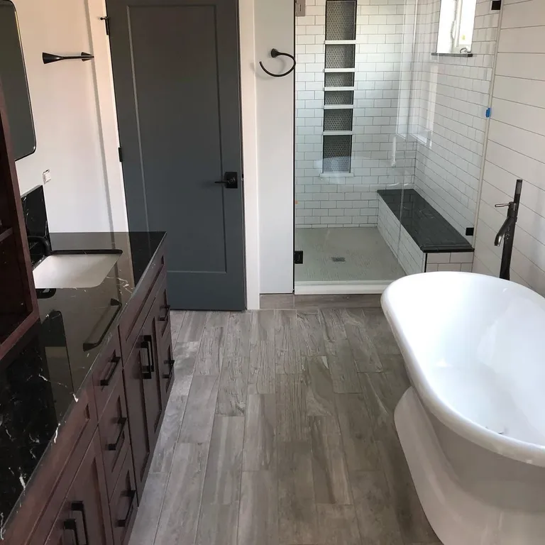 Renovated bathroom with freestanding tub and tiled shower after post-construction cleaning