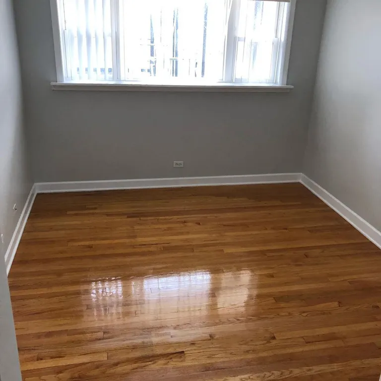 Empty room with polished hardwood floor ready for move-in after cleaning