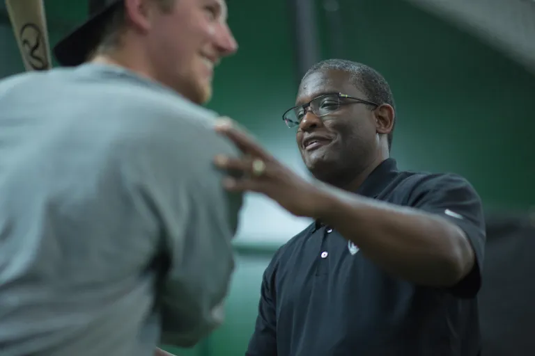 Coach Rick working with a baseball player during a hitting session