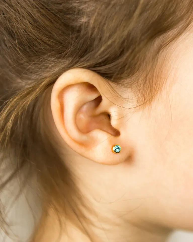 Ear piercing with a stud at Salon Salman