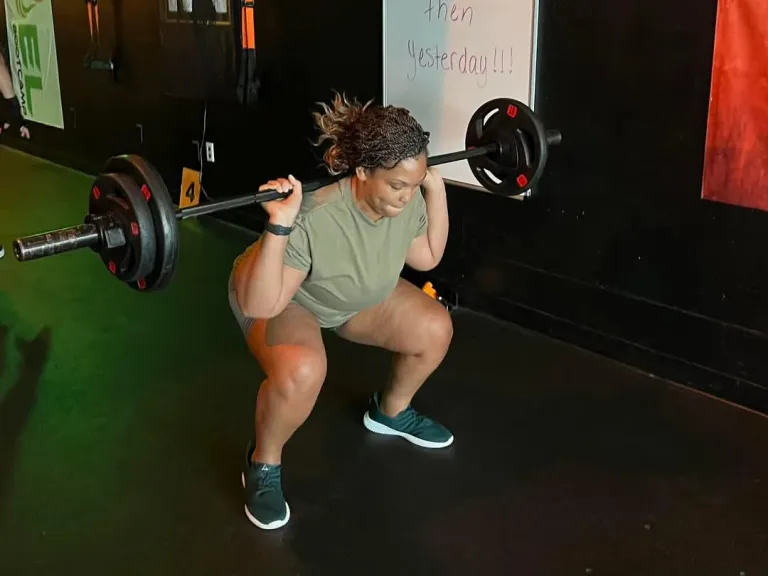 Member squatting a barbell at REFUEL Bootcamp Fort Walton Beach