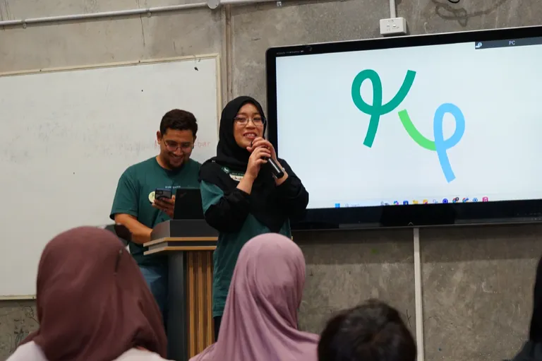 A KUM Youth presentation in front of the logo