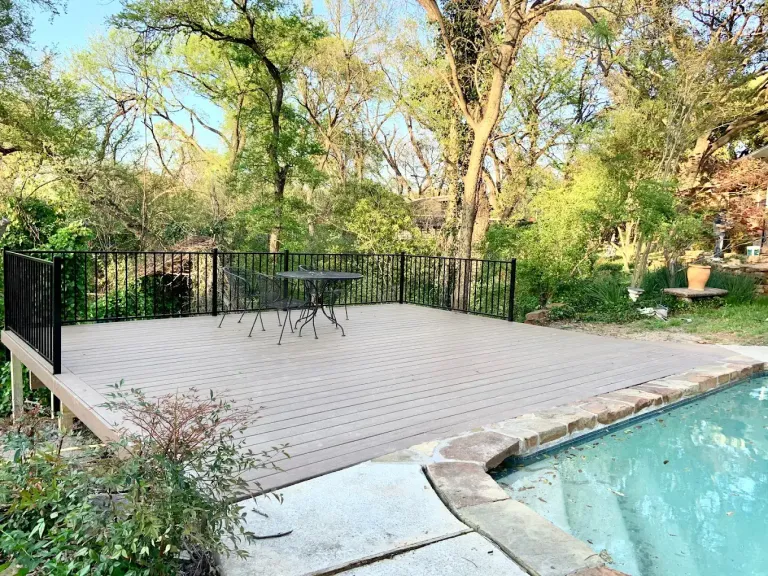 Pool deck surrounded by a black metal pool fence