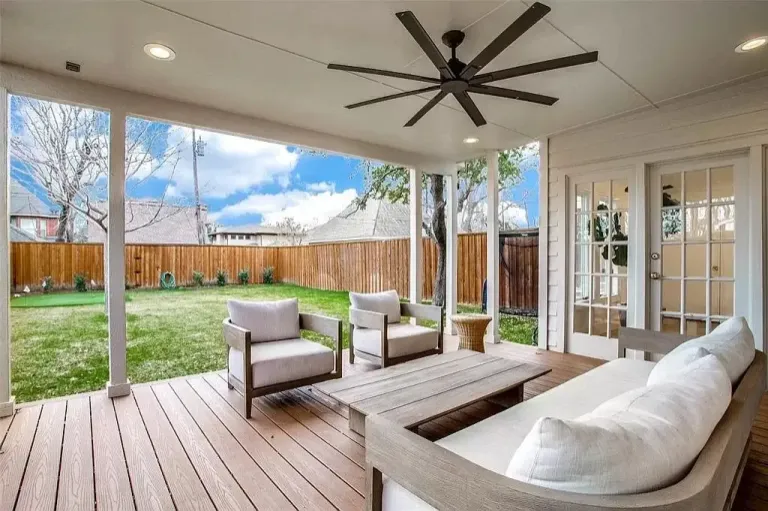 Covered patio with a wood deck floor, ceiling fan and outdoor seating