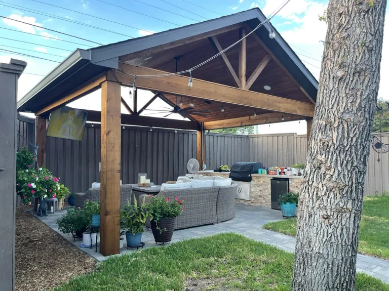 Cedar pavilion with a gabled roof over an outdoor living area and grill