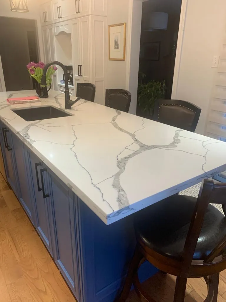 Navy kitchen island with marble-look waterfall quartz top