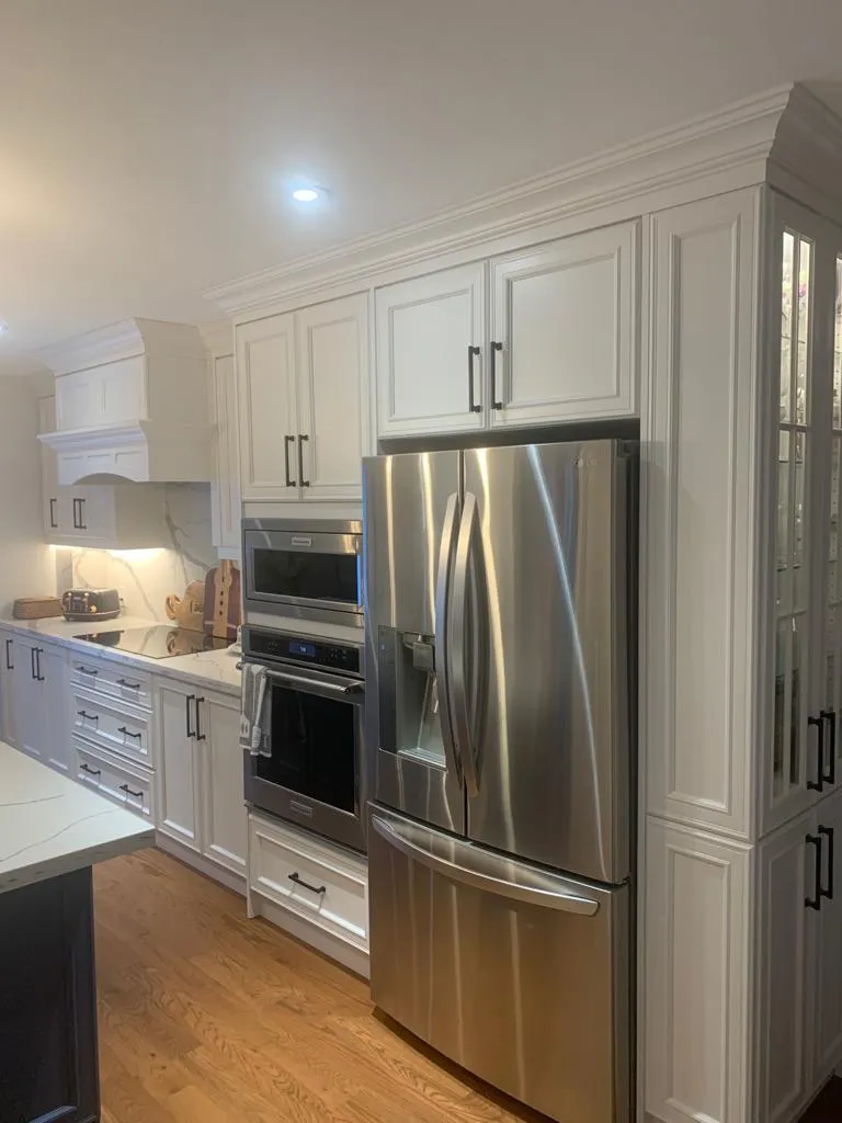 White kitchen with tall pantry cabinets and stainless French-door fridge