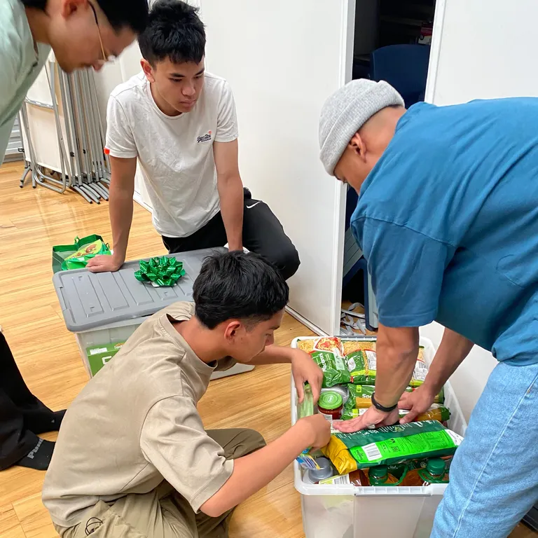 Volunteers packing hampers on the hall floor