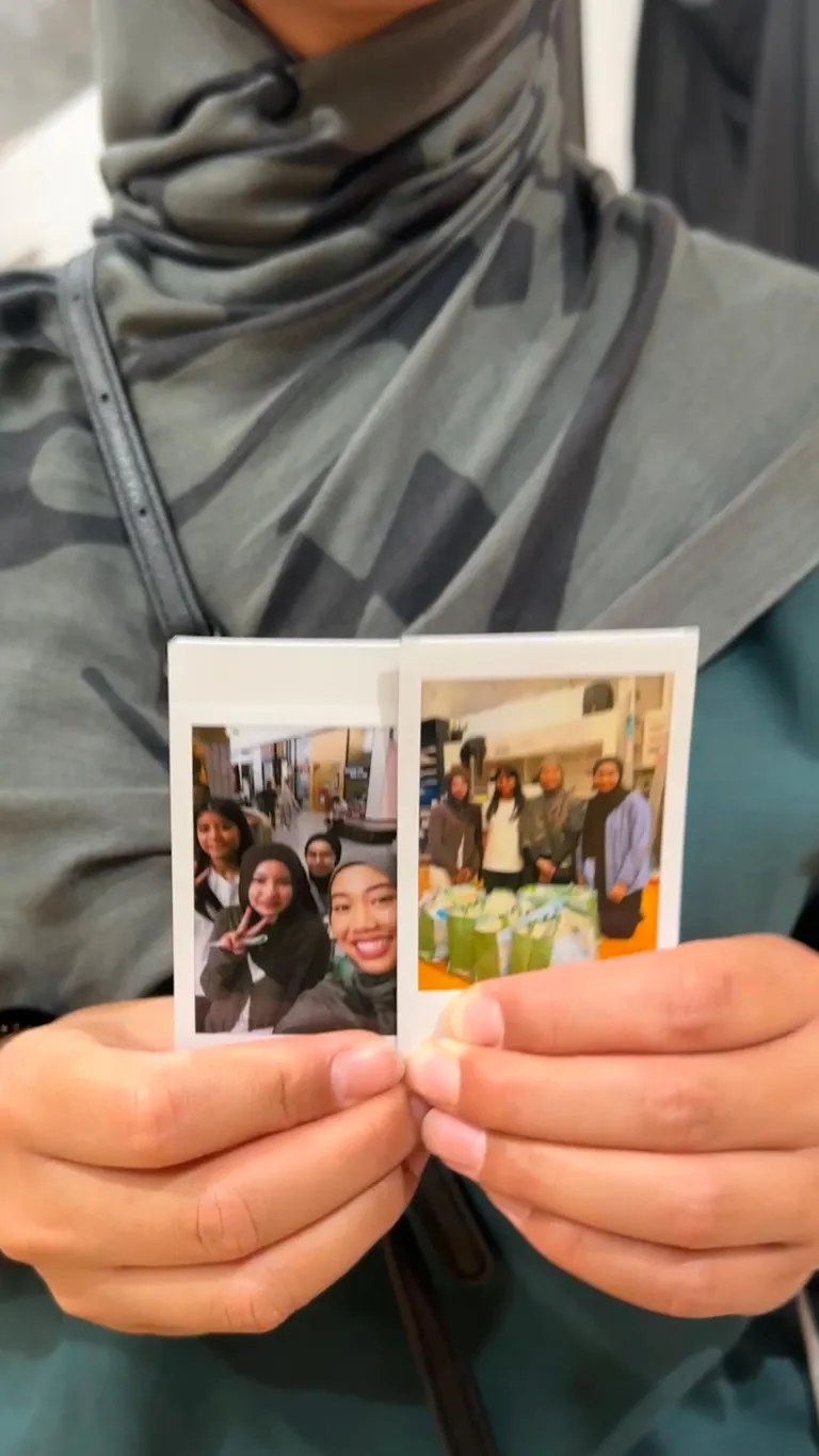 A volunteer holding instant photos from the day