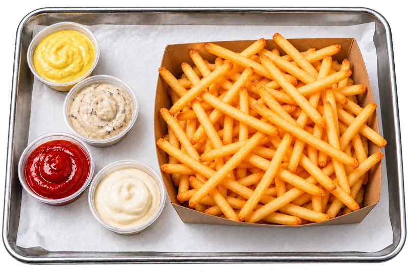 Skinny Fries in einer Pappschale mit Saucen