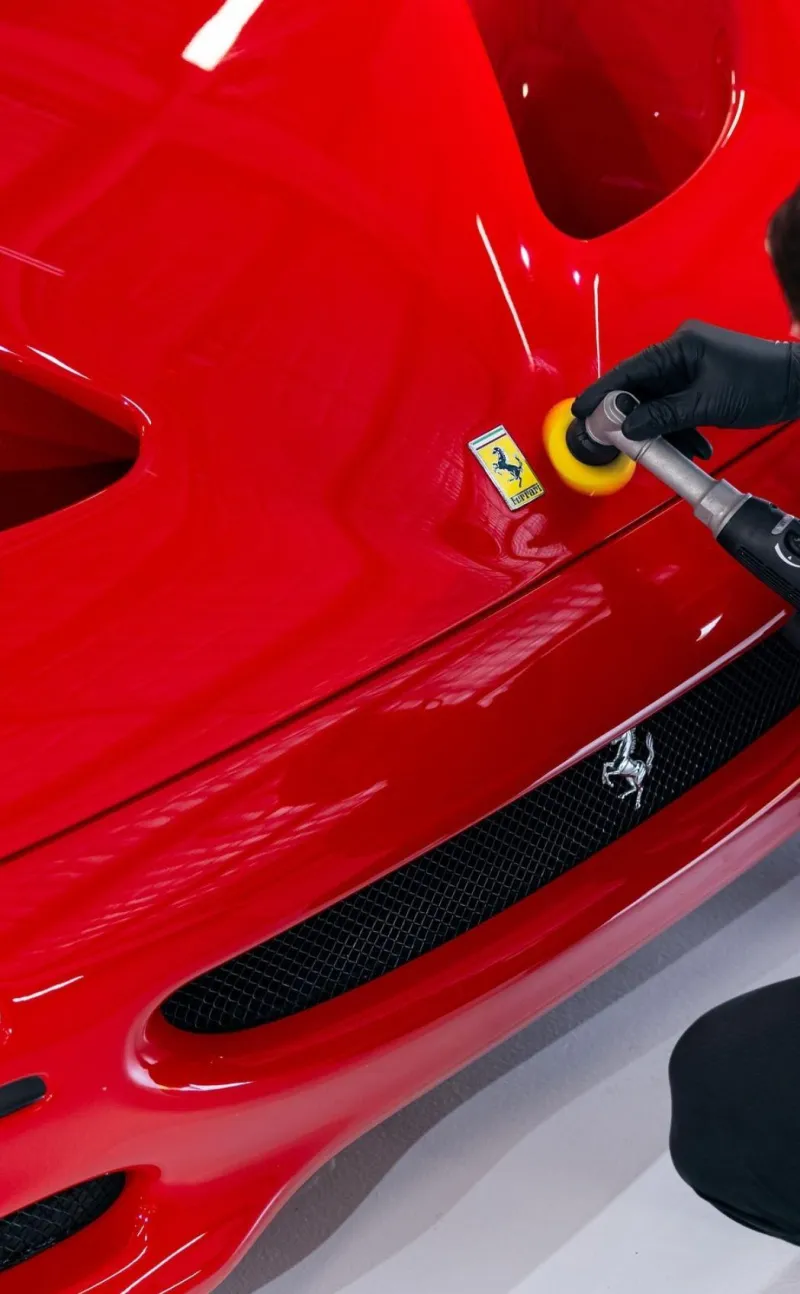 Polishing a red Ferrari panel by machine