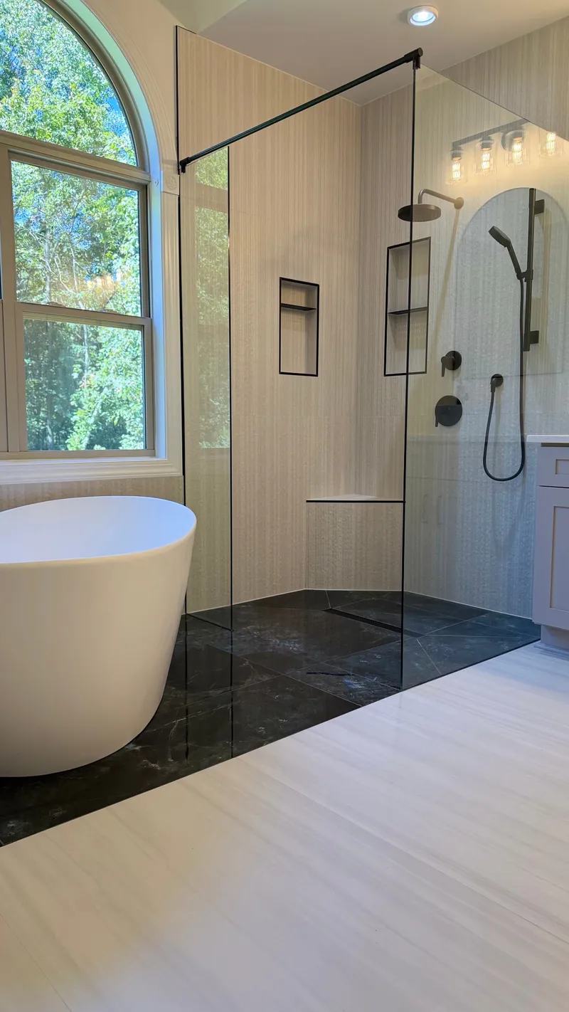 Glass shower with matte-black fixtures, corner bench and recessed niches