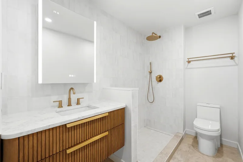Spa bathroom with curbless walk-in shower, zellige tile and brass fixtures