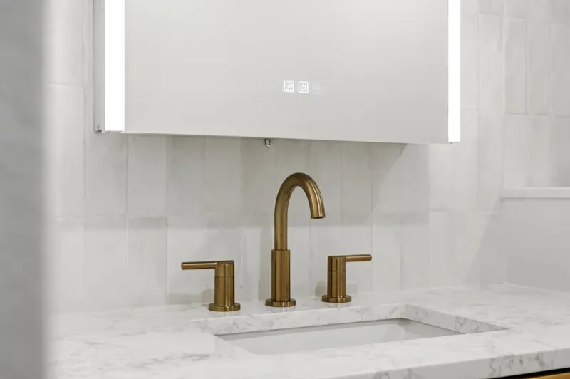 Marble vanity top with widespread brushed gold faucet and backlit LED mirror