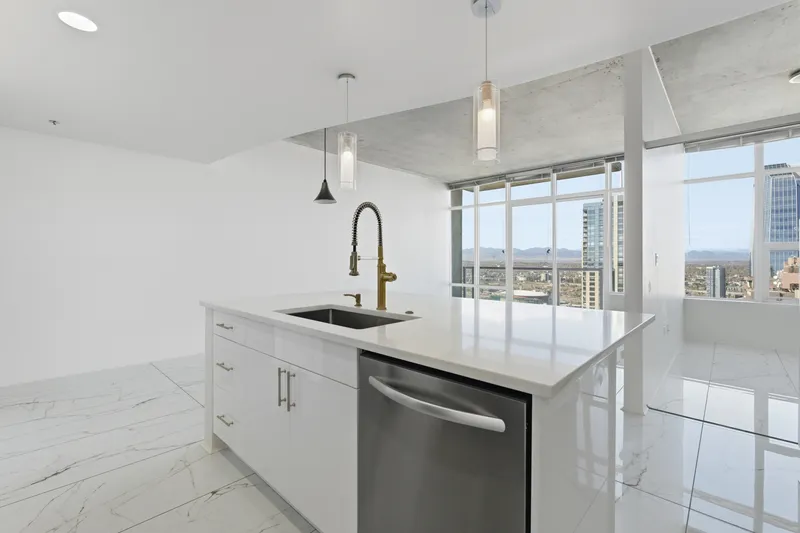 Condo kitchen island with undermount sink, gold pull-down faucet and floor-to-ceiling windows