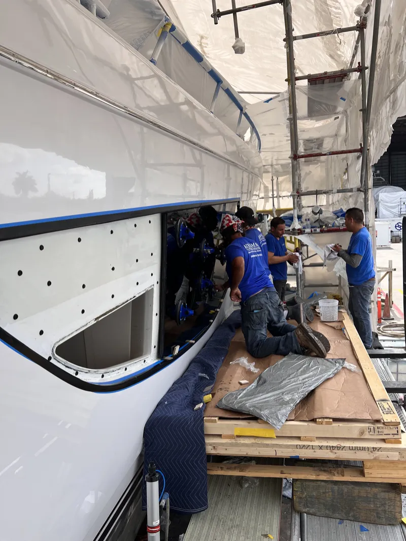 Aquamare team bonding a new hull window into place