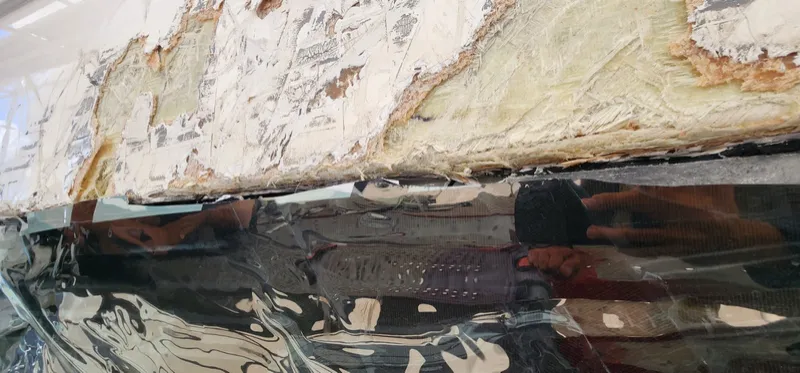 Close up of crushed laminate and sheared fairing along the hull side