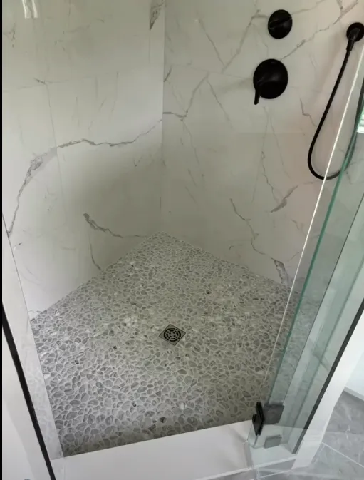 Close-up detail of a pebble stone shower floor from the same project