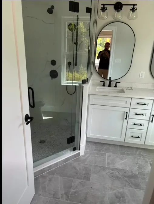 Walk-in shower with tiled walls and a pebble stone floor
