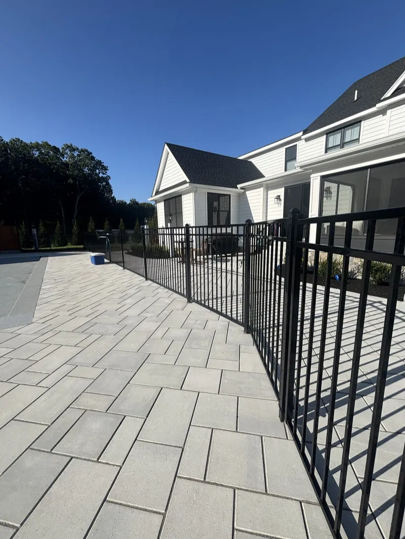 Black aluminum pool fence beside a new home in North Reading by All Fenced In