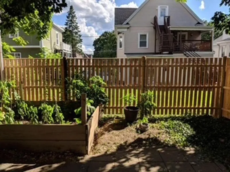 Wood picket fence around a garden by All Fenced In