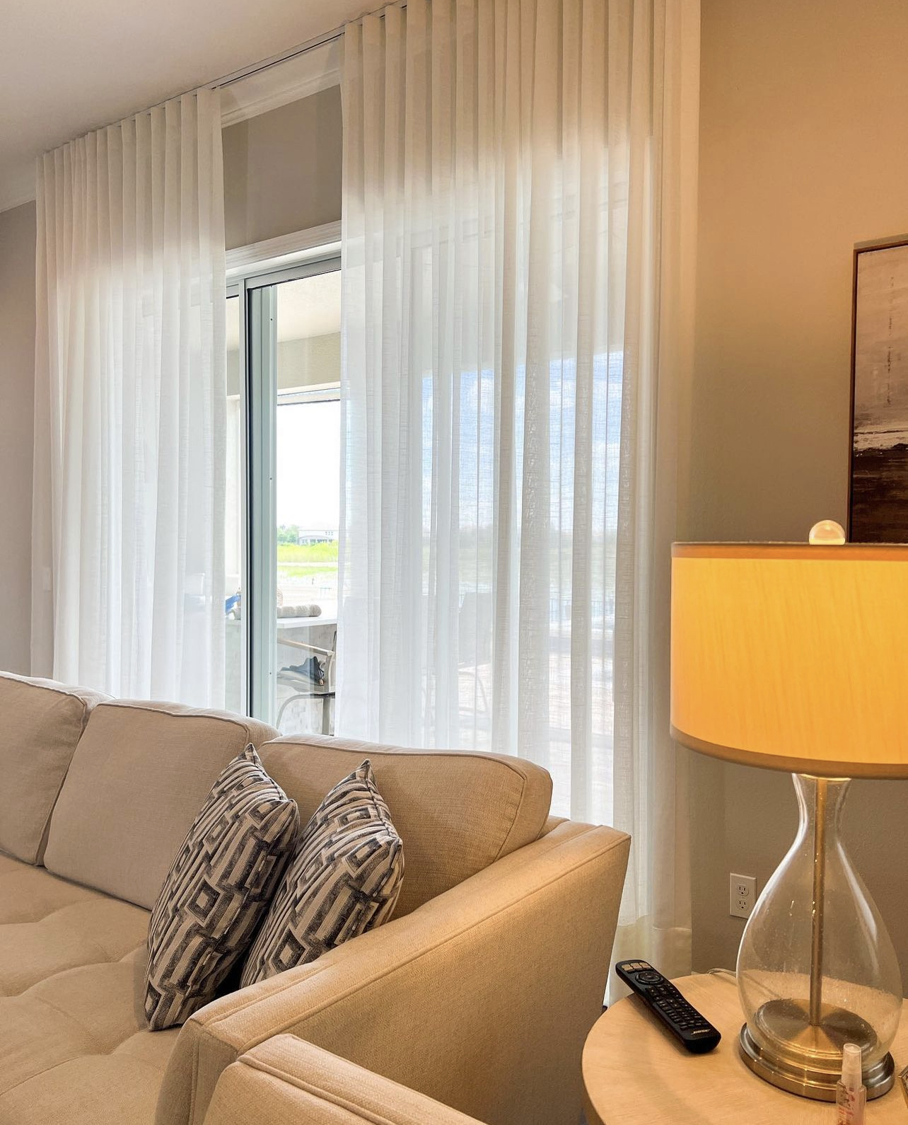 Floor-length white sheer drapes across the windows of a living room