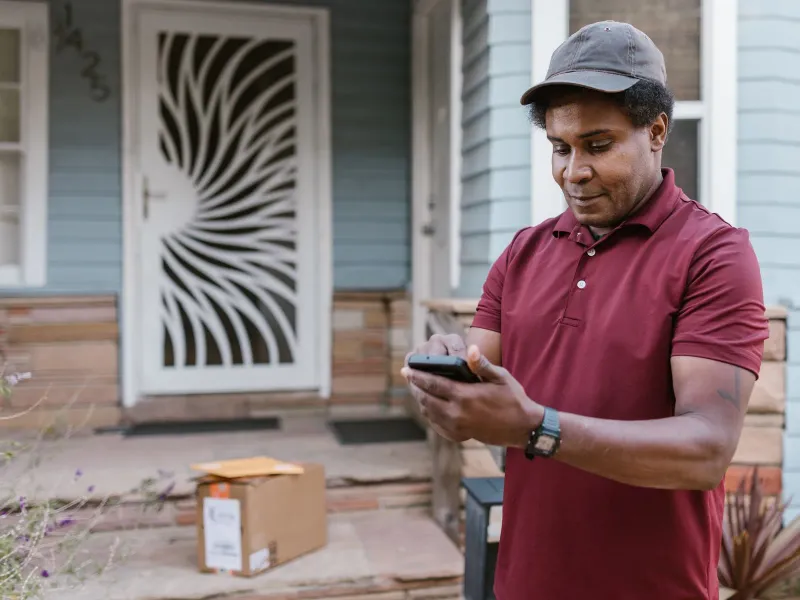 A man on his front porch checking his phone