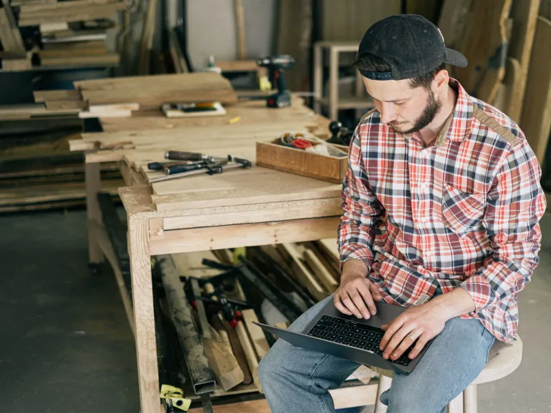 An owner in his workshop working on a laptop