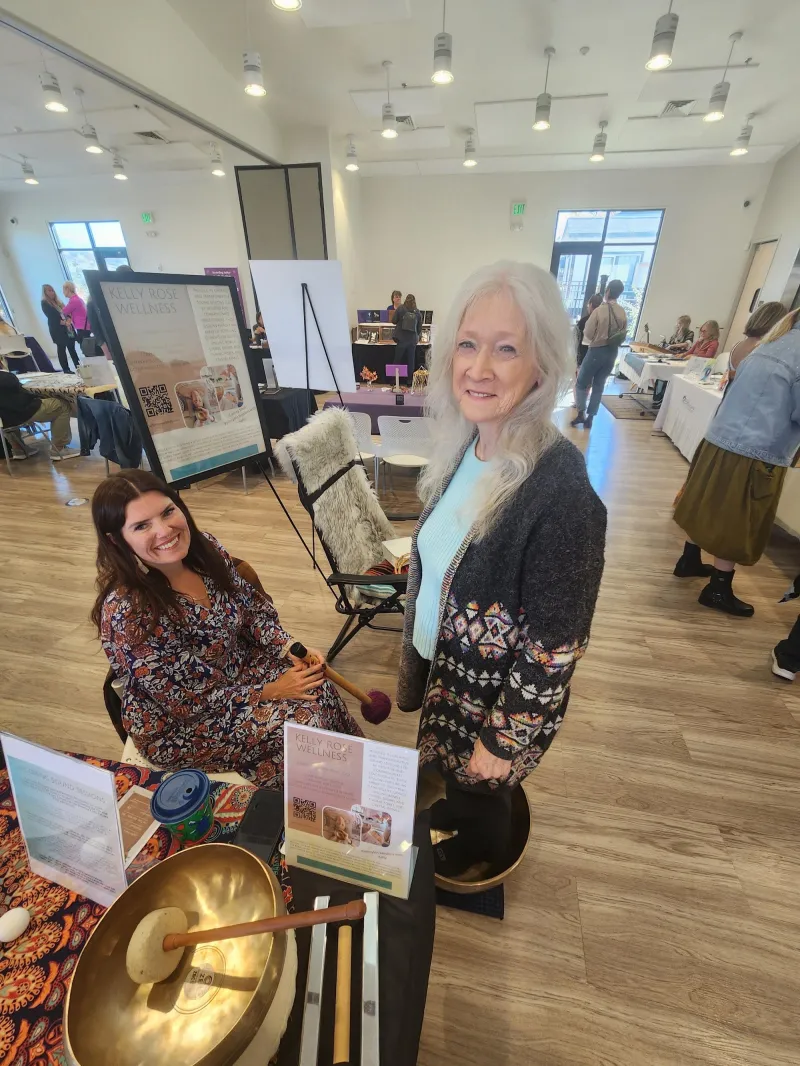 Kelly Rose with a guest at her sound healing table