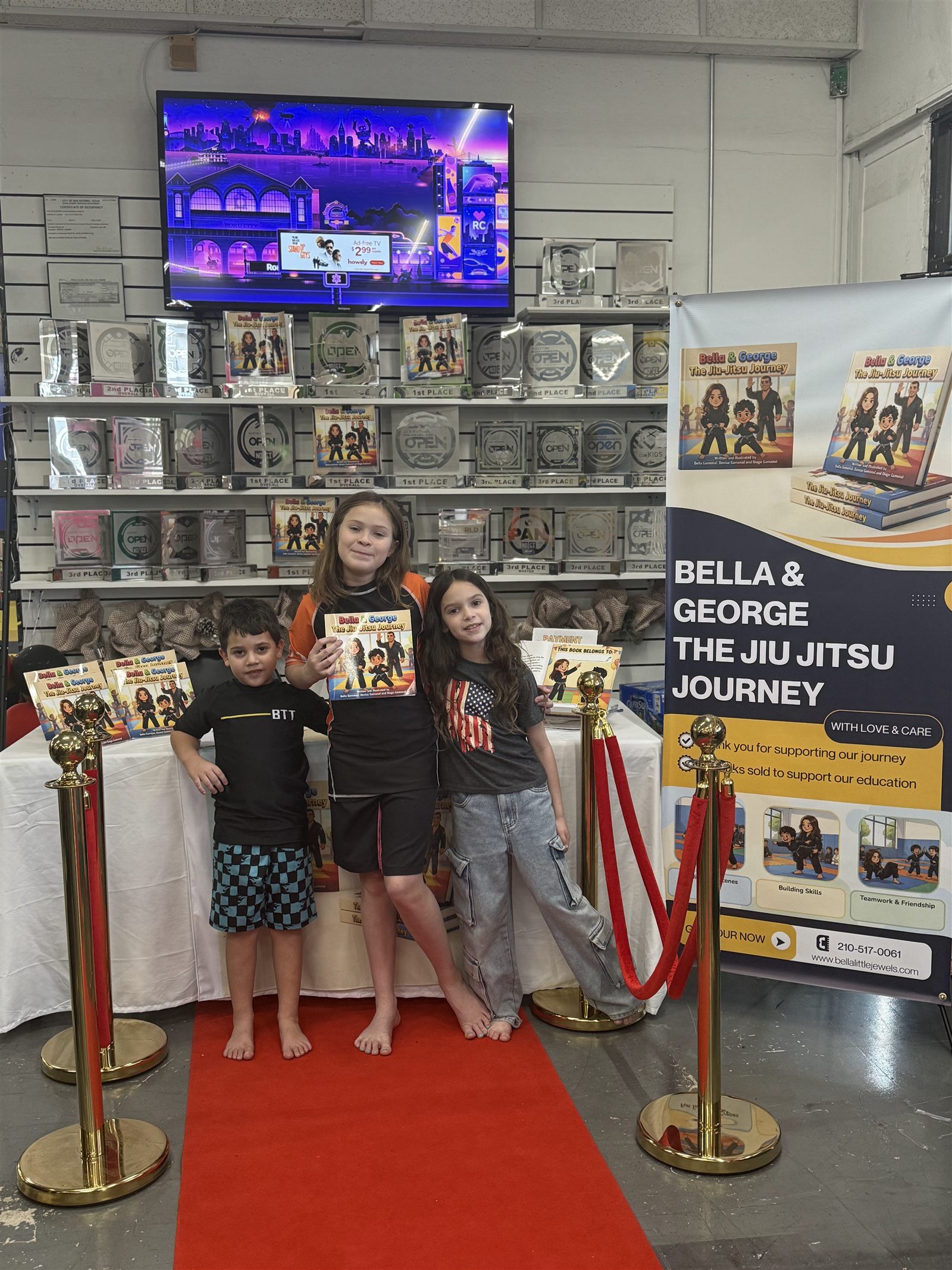 Bella and George: The Jiu Jitsu Journey book display with Denise's kids