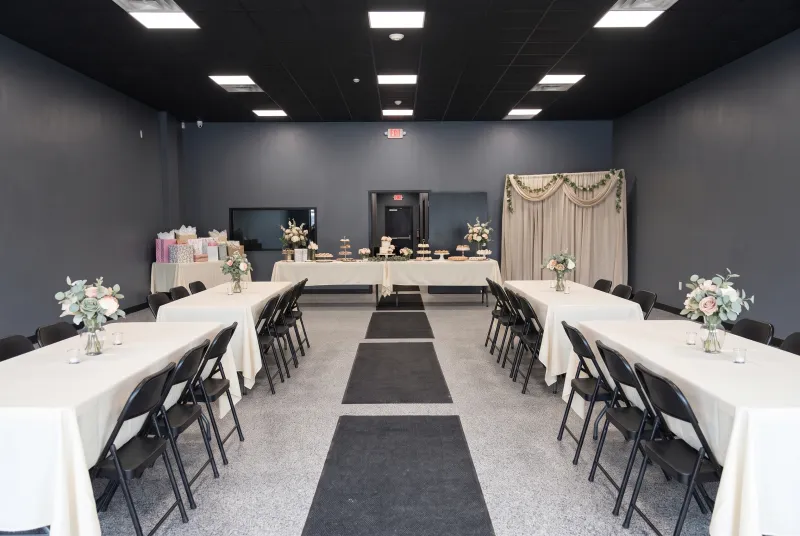 Event room set for a bridal or baby shower with a dessert table and gift table