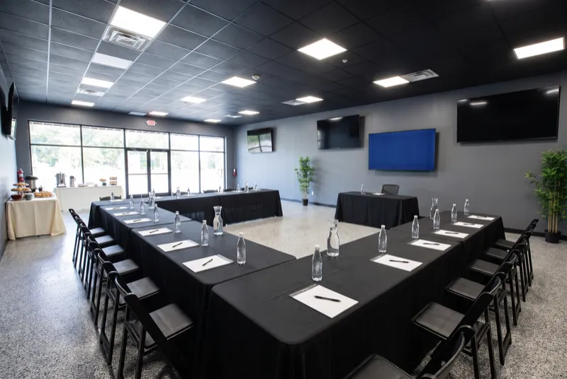 Event room set for a business meeting with folding tables in a conference layout