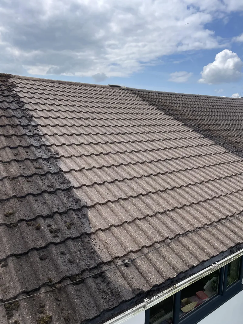 Roof cleaning on a concrete tiled roof, half cleaned